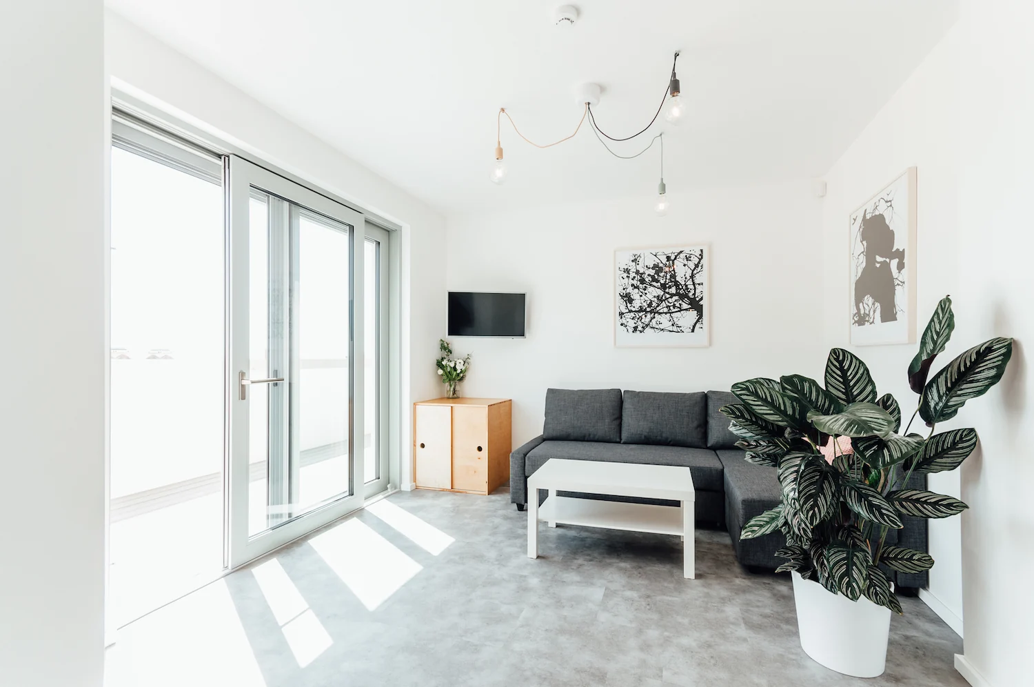 Prosvětlený obývací pokoj apartmánu 2 otevřený na terasu